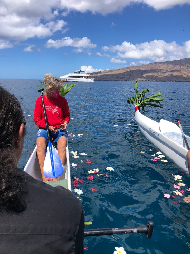 double hull canoe with flowers on the water